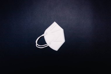 Milan, İtalya - Ocak 2022: Yüz maskesi (FFP2) siyah arka planda, boş bir alanda