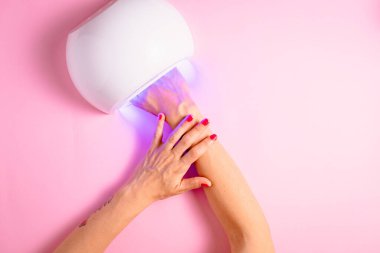 Tırnak cilasını kurutan kadınların elleri.