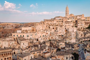 Matera, İtalya - Ağustos 2021: Sassi di Matera 'nın Belvedere di San Pietro Barisano' dan görünüşü, bulutlu mavi gökyüzü
