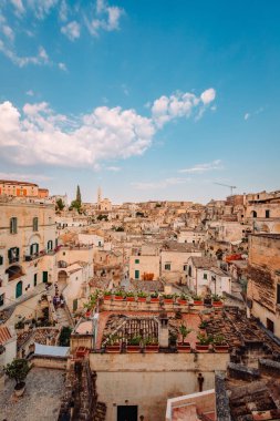Matera, İtalya - Ağustos 2021: Matera Sassisinin Luigi Guerricchio Belvedere 'den geniş görüşü, bulutlu mavi gökyüzü, dikey