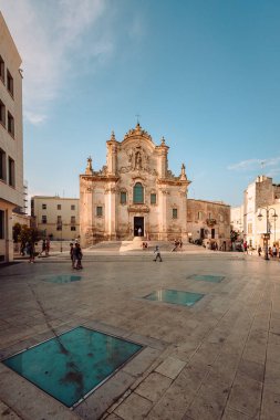 Matera, İtalya - Ağustos 2021: Matera 'daki San Francesco d' Assisi Kilisesi 'nin geniş görüşü, bulutlu mavi gökyüzü