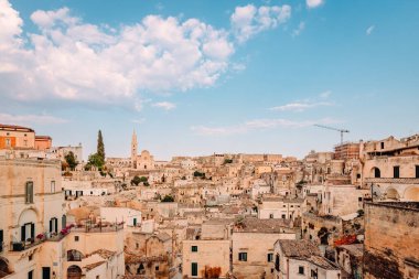 Matera, İtalya - Ağustos 2021: Luigi Guerricchio Belvedere 'den Matera' lı Sassi, bulutlu mavi gökyüzü
