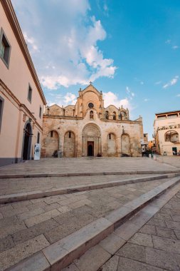 Matera, İtalya - Ağustos 2021: Matera 'daki San Giovanni Kilisesi' nin geniş görüşü, bulutlu mavi gökyüzü, dikey