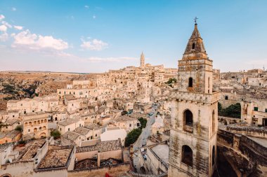 Matera, İtalya - Ağustos 2021: Sassi di Matera 'nın Belvedere di San Pietro Barisano' dan geniş görüşü, bulutlu mavi gökyüzü