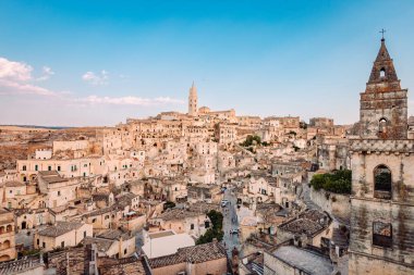 Matera, İtalya - Ağustos 2021: Sassi di Matera 'nın Belvedere di San Pietro Barisano' dan geniş görüşü, bulutlu mavi gökyüzü