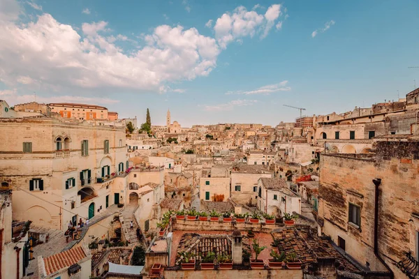 Matera, İtalya - Ağustos 2021: Ampia vista dei Sassi di Matera dal Belvedere Luigi Guerricchio, cielo azzurro con nuvole