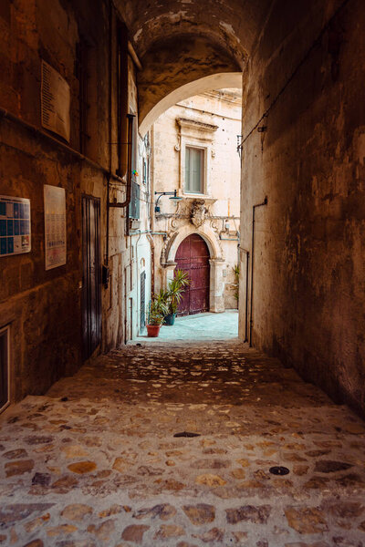 Matera, Italy - August 2021: Covered alleyway in the Sassi of Matera, vertical