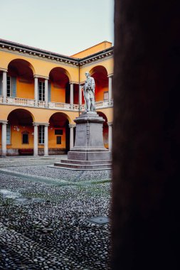 Pavia, İtalya - Ocak 2022: Pavia Üniversitesi 'nin merkezinde heykeli bulunan avlu