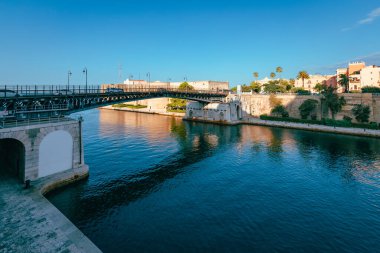 Taranto, İtalya - Ağustos 2021: Deniz üzerindeki köprü, Ponte Girevole, bulutlu mavi gökyüzü