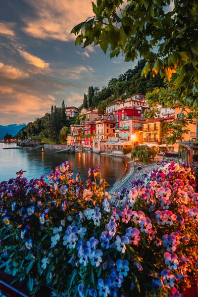 Varenna, İtalya - Mayıs 2021: Como Gölü üzerindeki Varenna köyü gün batımında aydınlık evlerle