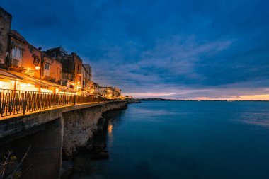 Siracusa, İtalya - Mart 2022: Ortigia 'nın günbatımında denizde uzun süre görülmesi