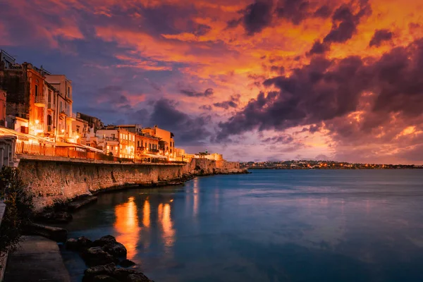 Siracusa, İtalya - Mart 2022: Ortigia 'nın deniz üzerinde muhteşem gün batımıyla uzun süre görülmesi