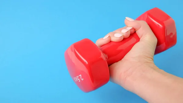 Fitness Concept Ένα Γυναικείο Χέρι Κρατά Ένα Κόκκινο Πλαστικό Αλτήρα — Φωτογραφία Αρχείου