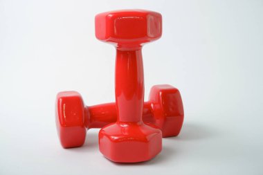 Beyaz arka planda plastik bir kılıfta dambıllar. Antrenman ekipmanları. Spor ve egzersizler..