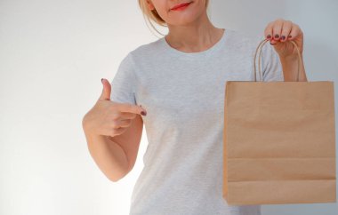 Ekolojik ambalaj. Kız elinde kese kağıdı tutuyor. Mutlu, sevimli, tanınmayan kadın eve çevre dostu geri dönüşümlü kağıt torbalarla geldi..