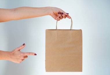 Ekolojik ambalaj. Kız elinde kese kağıdı tutuyor. Mutlu, sevimli, tanınmayan kadın eve çevre dostu geri dönüşümlü kağıt torbalarla geldi..