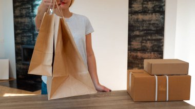 Ekolojik ambalaj. Tanınmayan sevimli bir kadın sana geri dönüşümlü kağıttan yapılmış eko torbaları veriyor. Alışveriş konsepti, doğal malzemeler, ekolojik tarz konsepti