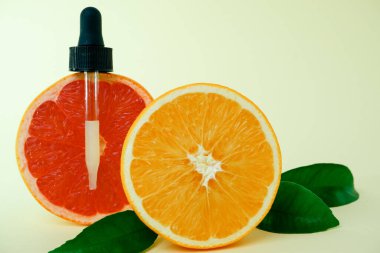 İçi narenciye yağı dolu bir şişe. Sulu olgun turunçgil dilimleri. lemon. Turuncu. Greyfurt. Üzüm. Cilt bakımı. Kozmetoloji.