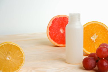 Vitaminler. Turunçgillerin arka planında vitamin için beyaz boş bir şişe. lemon. Turuncu. Boş ilaç şişesi.