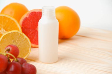 Vitaminler. Turunçgillerin arka planında vitamin için beyaz boş bir şişe. lemon. Turuncu. Boş ilaç şişesi.