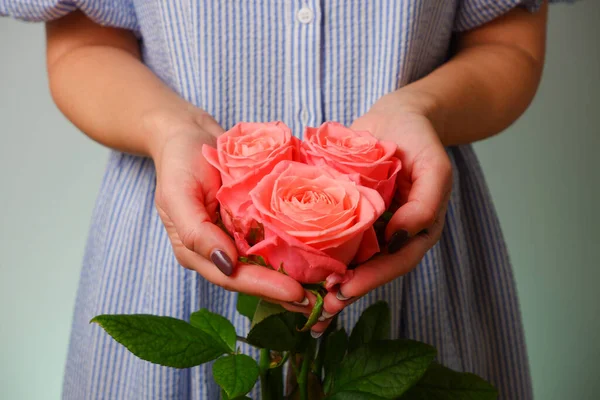穿着蓝色衣服的女人手里拿着精致的粉红色玫瑰花 头戴白色指甲 手持娇嫩粉红玫瑰花的女装手 — 图库照片