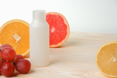 Vitaminler. Turunçgillerin arka planında vitamin için beyaz boş bir şişe. lemon. Turuncu. Boş ilaç şişesi.