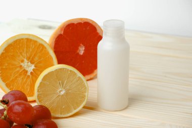 Vitaminler. Turunçgillerin arka planında vitamin için beyaz boş bir şişe. lemon. Turuncu. Boş ilaç şişesi.