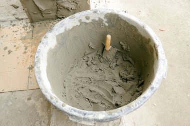Konteynırdaki çimento alçısından. Bir duvarı alçılama işlemi.