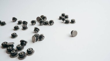 Kış çivili lastiklerin tamiri. Beyaz arka plana saçılmış çivileri onardı. Kayıp lastik çivileri değiştirildi.