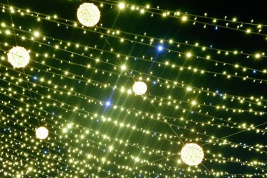 Noel Altını Parlayan Arkaplan. Siyah arka planda bulanık sarı Noel ışıkları. Yeşil çelenk. Yeni Yıl Işığı.