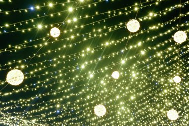 Noel Altını Parlayan Arkaplan. Siyah arka planda bulanık sarı Noel ışıkları. Yeşil çelenk. Yeni Yıl Işığı.