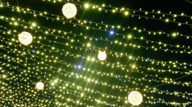 Noel Altını Parlayan Arkaplan. Siyah arka planda bulanık sarı Noel ışıkları. Yeşil çelenk. Yeni Yıl Işığı.