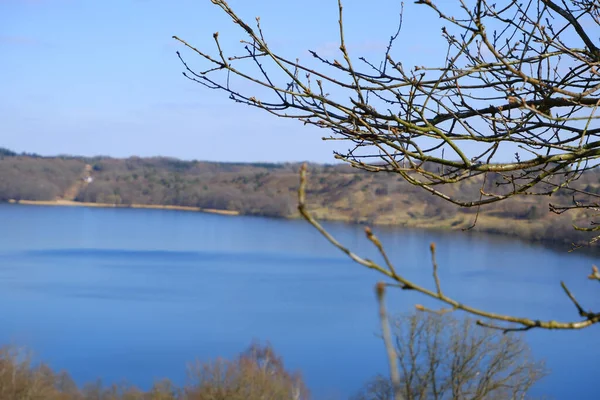春天里的风景 美丽的湖水被没有树叶的小山环绕着 早春湖边绿树成荫的春景 — 图库照片