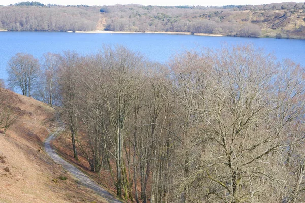 春天里的风景 美丽的湖水被没有树叶的小山环绕着 早春湖边绿树成荫的春景 — 图库照片