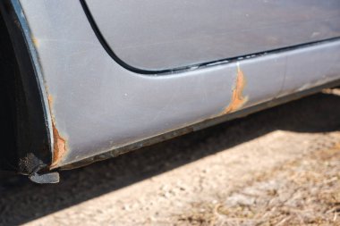 Korozyon, araba gövdesinde pas. Pas, aşınma ve boya zifti olan bir araba. Çevreye zarar veren maddeler konsepti. Seçici odak