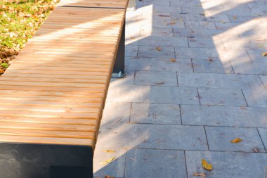 Manzara. Eski şehrin kaldırımlı kaldırımlı kaldırımları, ağaçların gölgesinde ahşap bir bank. Sokaktaki ahşap bank.