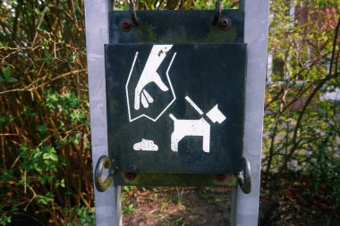 Kamu parkındaki hayvan dışkıları için çöp kutusu. Sokakta köpek pisliği temizliyorum. Parktaki evcil hayvan atıkları için bir tabela ve çöp kutusu