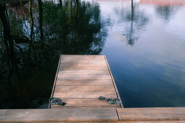 Manzara. Göldeki tekneler için ahşap set iskelesi. Şehir parkında yürümek için uygun bir yer. İskelesi ve güvertesi olan sıcacık su manzarası.