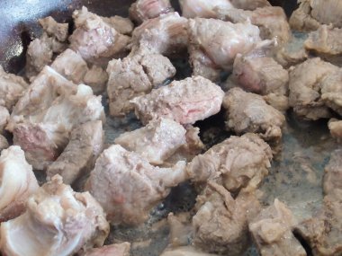 Et parçaları tavada kızartılır. Kızartma tavasında biftek Stroganoff, sığır etinden yapılmış bir tabak. Ev mutfağı. Yakın plan..