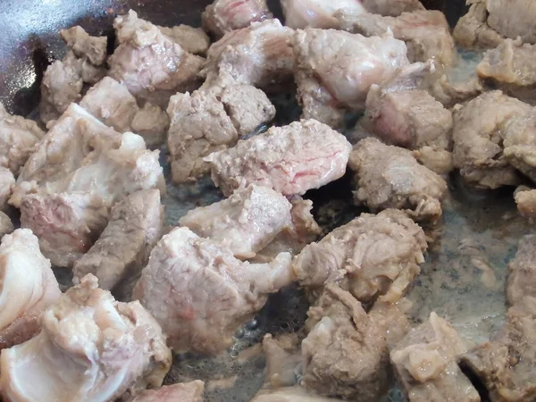 Et parçaları tavada kızartılır. Kızartma tavasında biftek Stroganoff, sığır etinden yapılmış bir tabak. Ev mutfağı. Yakın plan..