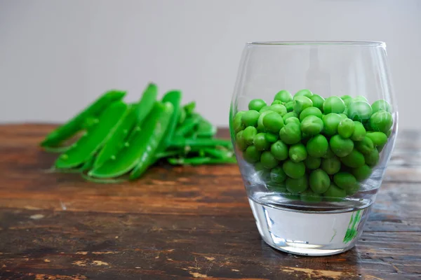 Ervilhas Verdes Taça Vidro Ervilha Fresca Vagem Com Folhas Verdes — Fotografia de Stock