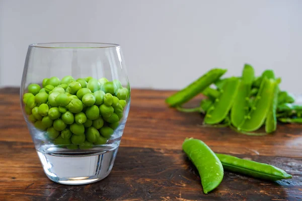 Ervilhas Verdes Taça Vidro Ervilha Fresca Vagem Com Folhas Verdes — Fotografia de Stock