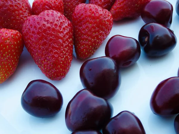 Berry mix. Strawberries and cherries on a white background. Fresh organic summer berries mix in white plate