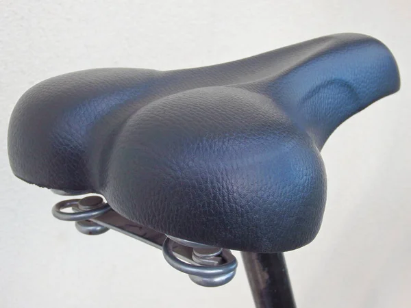 Black leather bicycle seat close-up. Bicycle seat on a white background. Cropped Image Of Bicycle On Street