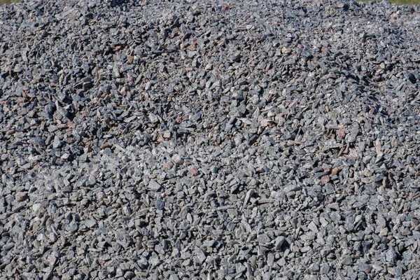 A Granite gravel texture. Texture of gray granite rubble. Background of natural grey granite crushed stone