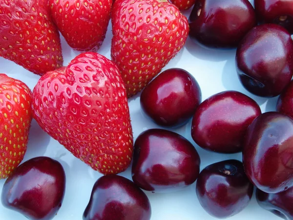 Berry mix. Strawberries and cherries on a white background. Fresh organic summer berries mix in white plate