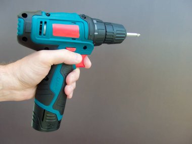 Elektirikli tornavidayla el adamı. İşçi elektrikli matkap tornavida kullanıyor, yakın plan. Onarım ve inşaat hizmetleri kavramı.