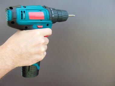 Elektirikli tornavidayla el adamı. İşçi elektrikli matkap tornavida kullanıyor, yakın plan. Onarım ve inşaat hizmetleri kavramı.