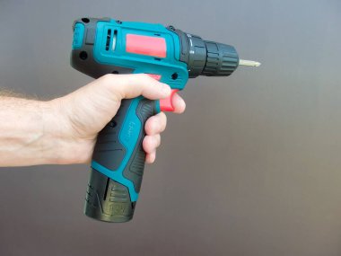 Elektirikli tornavidayla el adamı. İşçi elektrikli matkap tornavida kullanıyor, yakın plan. Onarım ve inşaat hizmetleri kavramı.