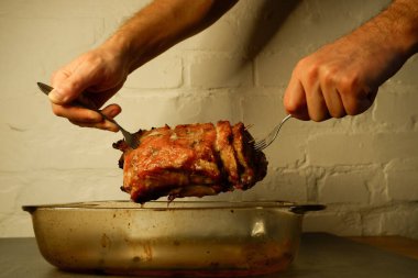 Aşçı elinde büyük bir kızarmış et parçası kaldırır. Kızarmış domuz bifteği kızartma tavasında, yakın görüş. Izgara fileto..
